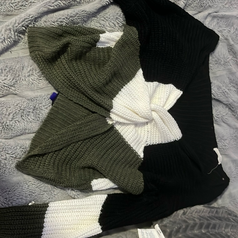 A sweater black white and green cross open parts